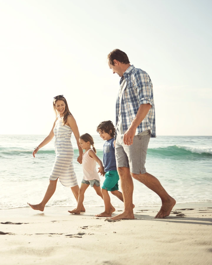 Famille avec enfants se dirigeant a la plage